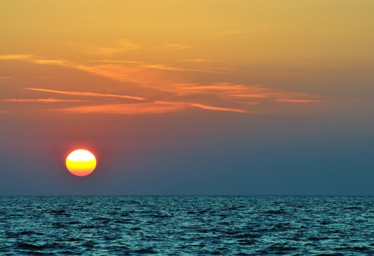 Beautiful colorful sunset over wavy waters of Black sea in Crimea on summer day. Natural landscape background and wallpaper